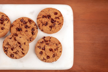 Chocolate chip cookies, shot from above on a dark rustic background with a place for text
