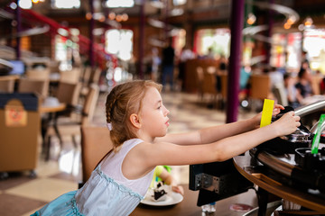 Blonde girl in white and blue dress having lunch in the restaurant