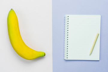 Table top view aerial image of count cal weight for sport fitness background concept.Flat lay essential objects notebook & pen with banana on modern rustic white & purple paper.Copy space for mock up.