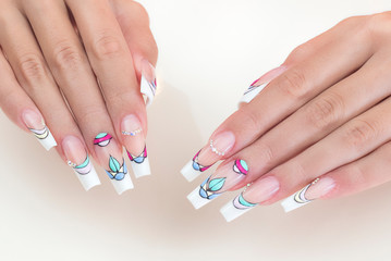 Manicure on nails isolated on cream background. Manicure with gems and sparkles. Trendy Accessories. Beauty hands. Stylish Nails