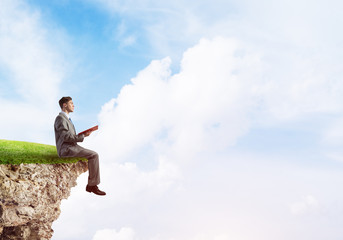 Student guy in suit with book in hands preparing for exam