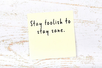 Positive inspiring quote handwritten on sticky note on wooden background