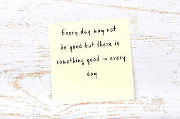 Positive inspiring quote handwritten on sticky note on wooden background