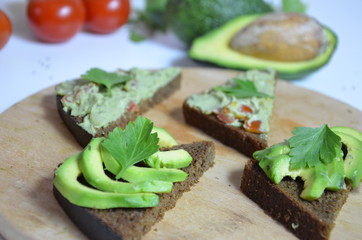 A delicious Bowl of Guacamole next to fresh ingredients on a table with tortilla chips and salsa. sandwich with guacamole, red hot pepper, lime, lemon, avocado