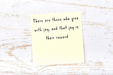 Positive inspiring quote handwritten on sticky note on wooden background
