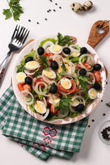 Healthy salad of organic lettuce with canned tuna, tomatoes, quail eggs, black olives and white onions 