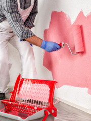 Professional house painter at work painting the wall © francescomou