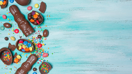 Chocolate traditional easter eggs and bunnies with bright colorful dragee and sugar sprinkles
