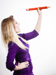 Smiling woman holds big pencil in hand