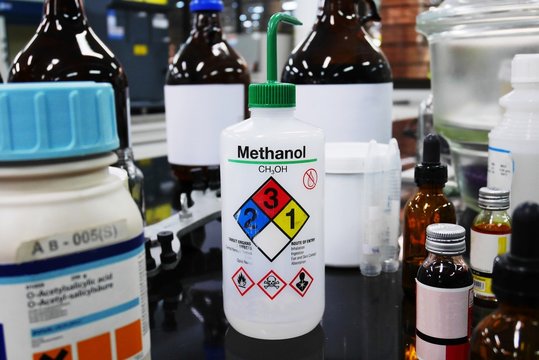 Bottle of Methanol and chemical with hazard symbols for experiment in Laboratory.