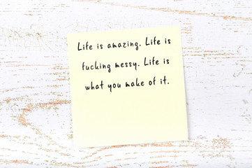 Positive inspiring quote handwritten on sticky note on wooden background