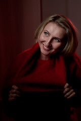 Portrait of a middle-aged woman in the room. Photography in the Studio. Photo shoot in a dark key