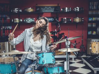 Fototapeta na wymiar Young girl enjoys a musical instrument store