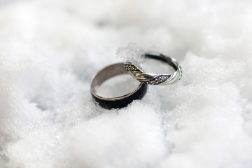 Obraz na płótnie Canvas wedding rings for her and him in winter time on the white snow 
