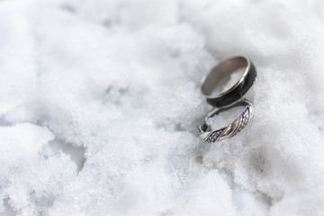 Obraz na płótnie Canvas wedding rings for her and him in winter time on the white snow 