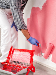 Professional house painter at work painting the wall © francescomou