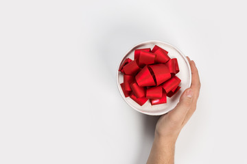 small present with red ribbon bow in man hands on white background
