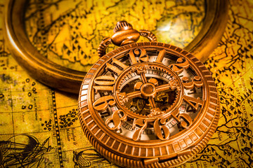Vintage magnifying glass and pocket watch. Map of the Ancient World in 1565.