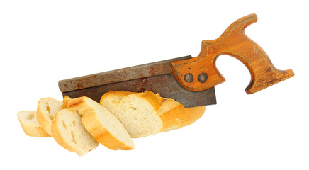 Old wooden handled saw sawing a crusty bread baguette isolated on a white background