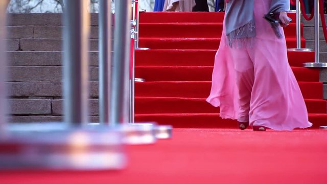An actress in a pink dress walking on the red carpet, close up