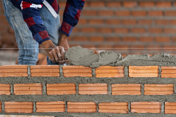 Closeup hand professional construction worker laying bricks in new industrial site. construct industry and masonry concept