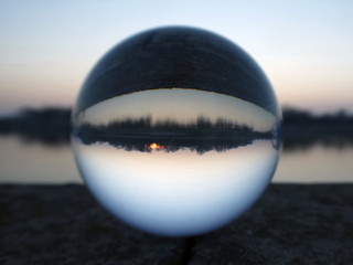 Sunrise reflection iover the river n the lens ball