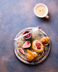 Croissant with figsJam and thyme. Breakfast cup of hot coffee on a dark background. Slack Dessert. Autumn Appetizer.Top View.Copy space for Text.