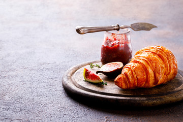 Croissant with figs Jam and thyme. Breakfast on a dark background. Slack Dessert. Autumn Appetizer.Copy space for Text.
