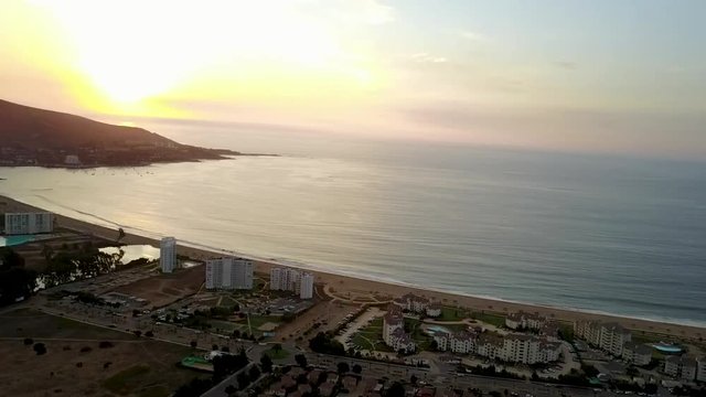 An aerial view of Papudo town and beach at Valparaiso region an amazing popular beach with sand dunes, a river and a very nice surf spot at central Chile, 4K Aerial Raw Drone Footage during sunset
