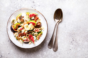 Salad with figs Mozzarella Thymean, Cedar Nut and honey.Healthy Food on the Stone Background. Nutrition Concept.Top View.Copy space for Text.