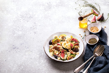 Salad with figs Mozzarella Thymean, Cedar Nut and honey.Healthy Food on the Stone Background. Nutrition Concept.Copy space for Text.