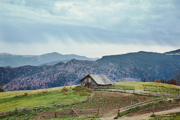 beautiful view of an autumn mountain landscape with a cloudy sky and farm