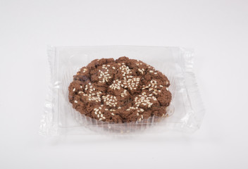 Oatmeal cookie in a plastic pack on a white