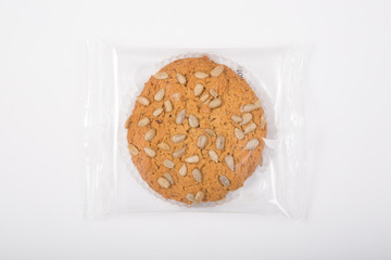 Oatmeal cookie in a plastic pack on a white
