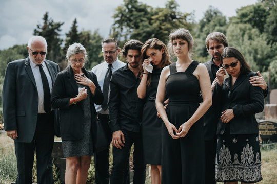 Sad Family Standing At A Cemetery