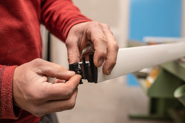 close up of a man hands assembling a piece of an aluminum door