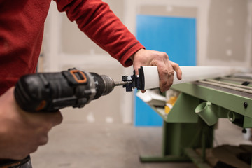 close up of a man hands assembling with a drill a piece of aluminum