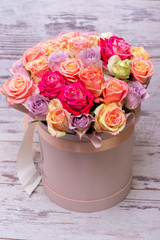 Beautiful bouquet of roses in a gift box. Bouquet of pink roses. Pink roses close-up. on wooden background, with space for text.