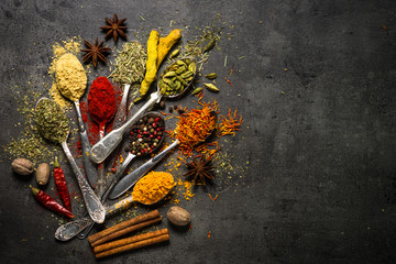 Set of various spices  on black stone background.