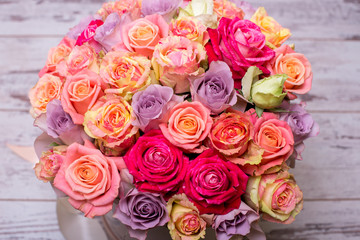 Beautiful bouquet of roses in a gift box. Bouquet of pink roses. Pink roses close-up. on wooden background, with space for text.