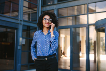 Business professional making a phone call outside office buildin