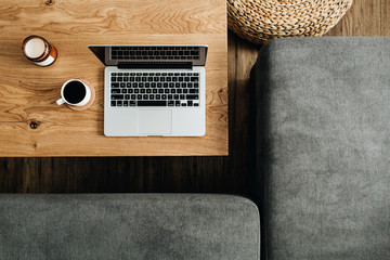 Top view of laptop, coffee cup and candle on wooden table. Blogger / freelancer home office...