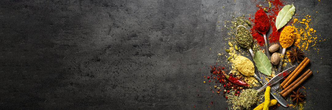Set of various spices on black stone background. © nadianb