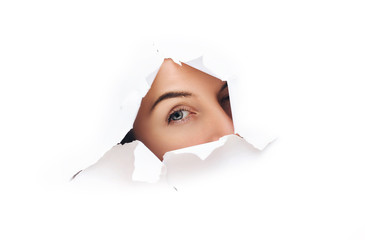 Voyeurism. A curious female look. Spying on or overhearing the concept. Hole on White paper.
