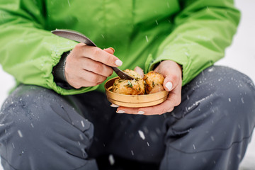 woman eating food in a winter forest.