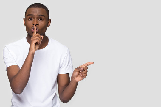 African american man holding finger on mouth keep it quiet