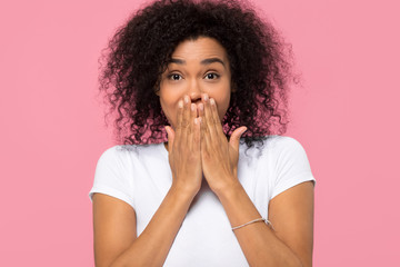 Amazed african woman covering mouth with hands looking at camera