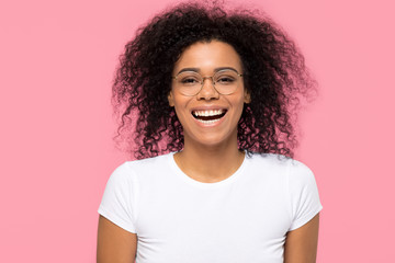 Fototapeta premium Cheerful african girl wearing glasses laughing isolated on pink background