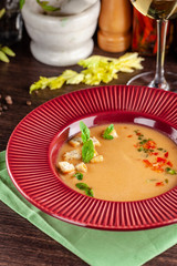 European Spanish cuisine. Summer tomato soup Gospacho with crackers, and vegetables. White wine on the table. Close-up background image. Beautiful serving dishes in the restaurant.