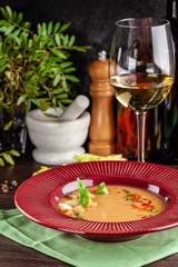 European Spanish cuisine. Summer tomato soup Gospacho with crackers, and vegetables. White wine on the table. Close-up background image. Beautiful serving dishes in the restaurant.